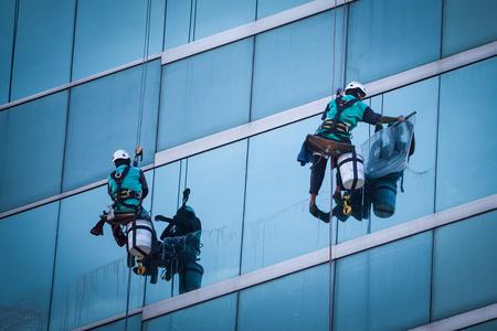 高层水管组工人清洗高层建筑上的 windows 服务照片
